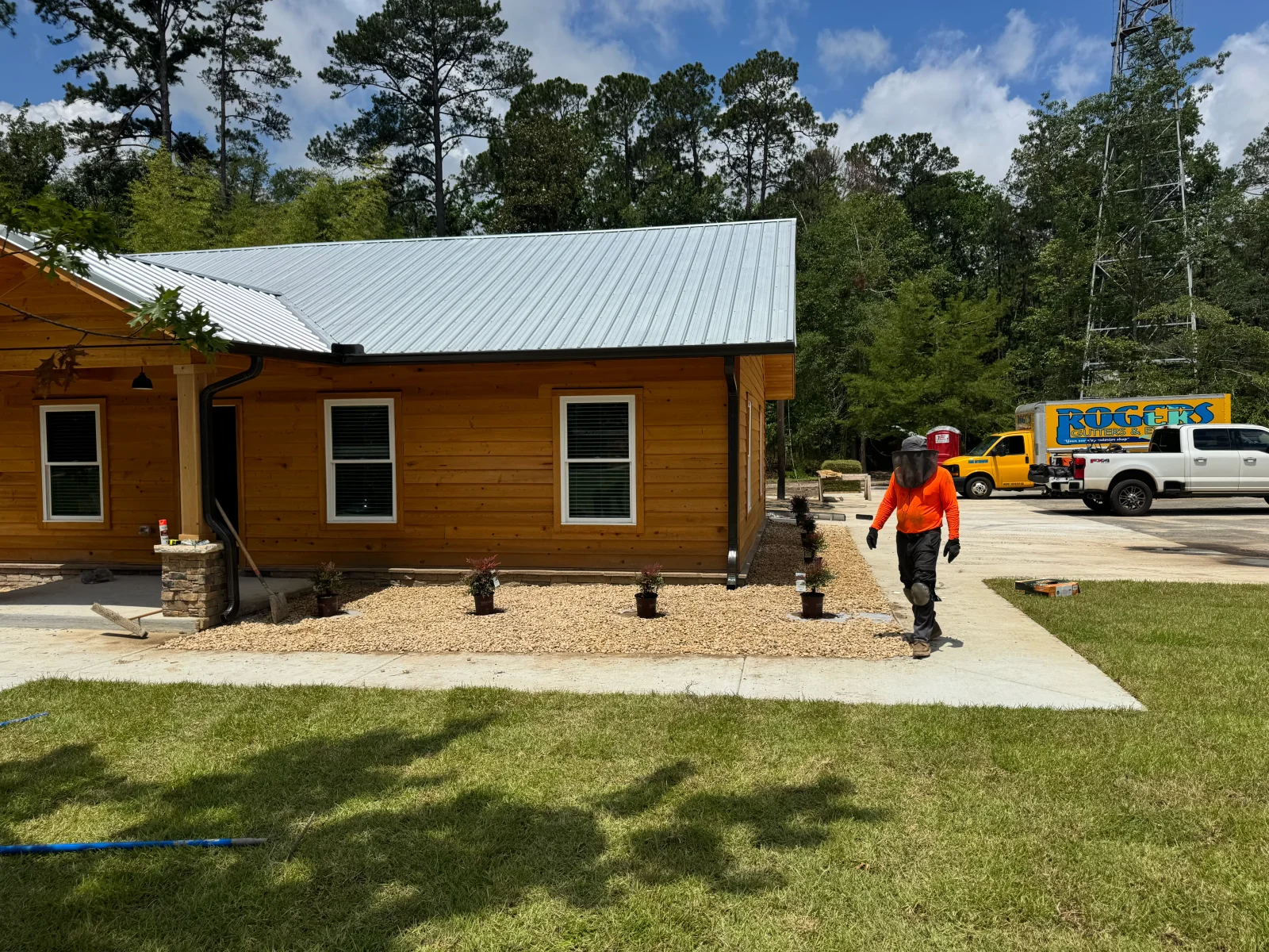 Concrete pad and foundation for wood-sided residential building with metal roof