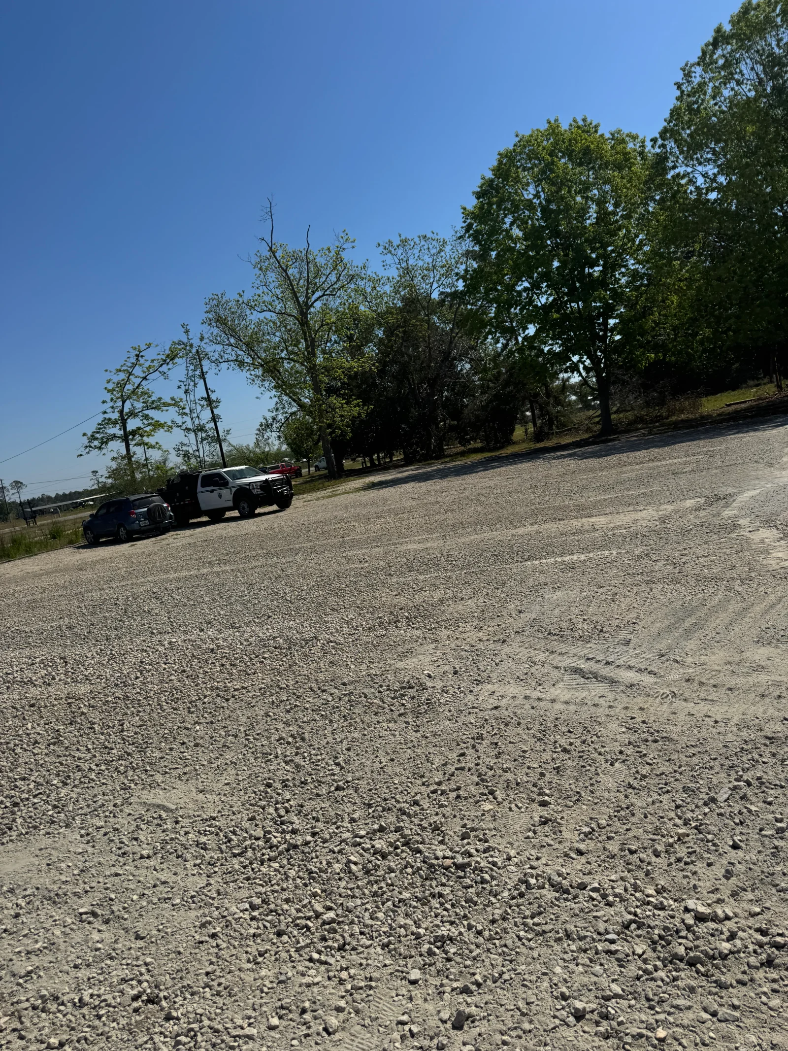 Compacted gravel driveway with crushed stone surface and service vehicle